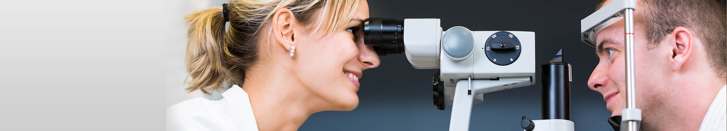 Smiling eye doctor performing eye exam